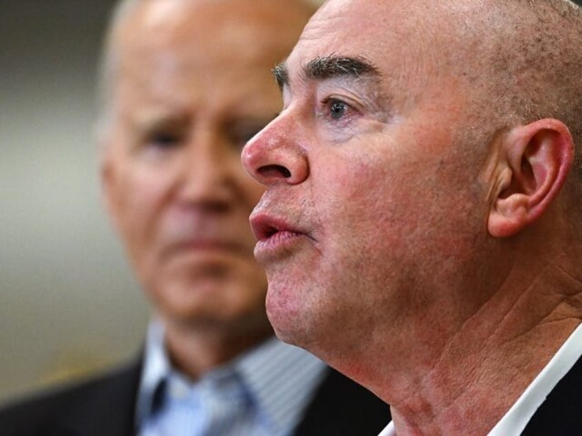 US President Joe Biden (L) listens as Homeland Security Secretary Alejandro Mayorkas speak