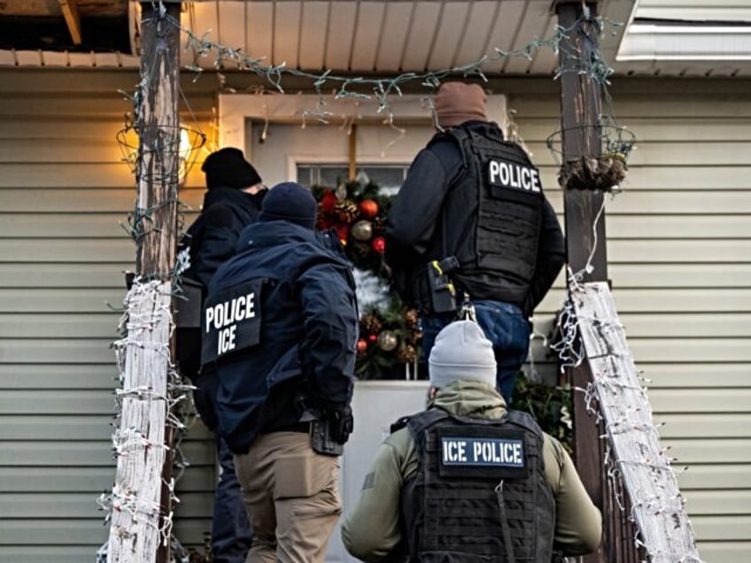 US Immigration and Customs Enforcement (ICE) agents knock on the door of a residence durin