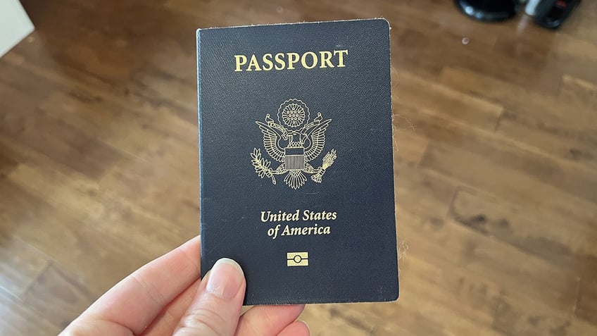 U.S. passport held in left hand