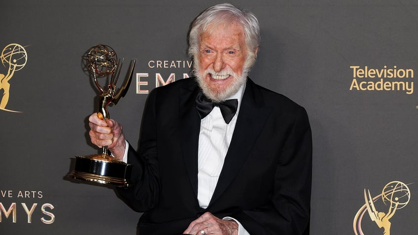 Dick Van Dyke in a classic tuxedo smiles as he grips his Creative Arts Emmy