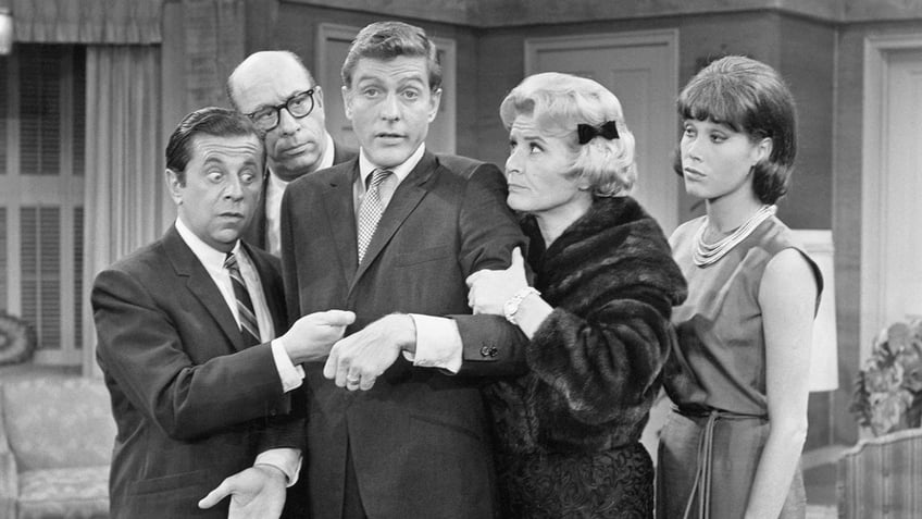 Rose Marie grabbing on to Dick Van Dyke as everyone looks stunned