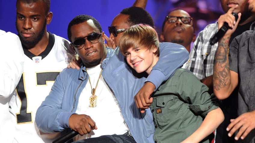 diddy with his arm around young justin biebers shoulder