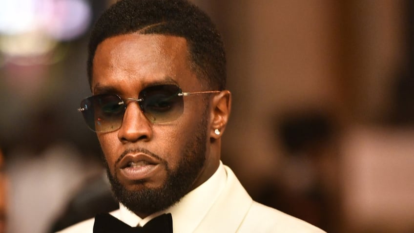 Sean Diddy Combs wears white tux with black bow tie.