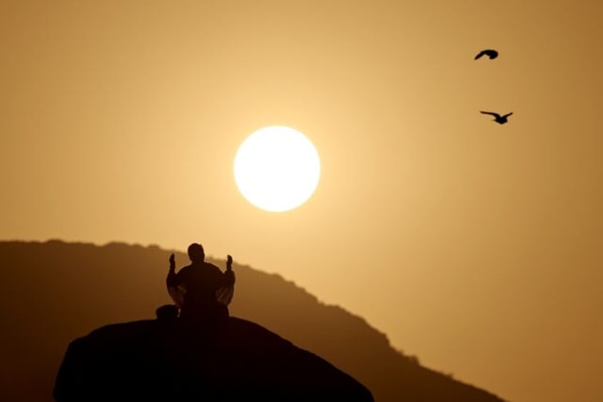 A Muslim pilgrim prays at dawn on Saudi Arabia's Mount Arafat during the climax of the haj