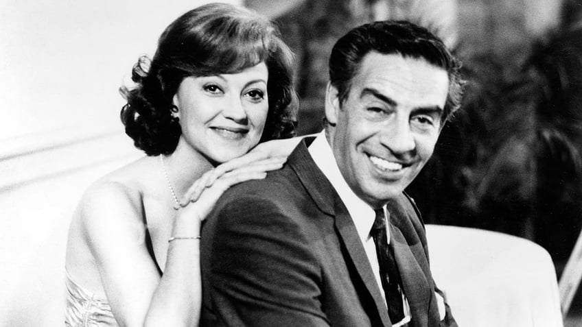 Kelly Bishop leaning against her co-star Jerry Orbach