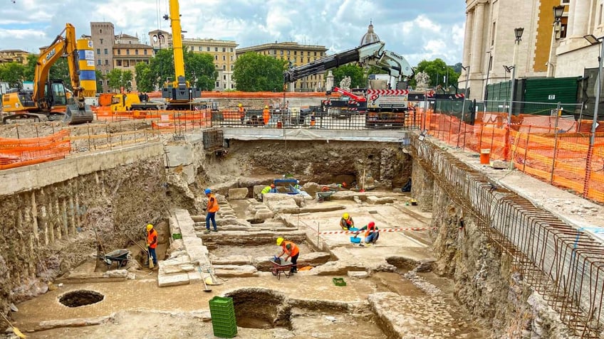 Construction workers working among ancient ruins