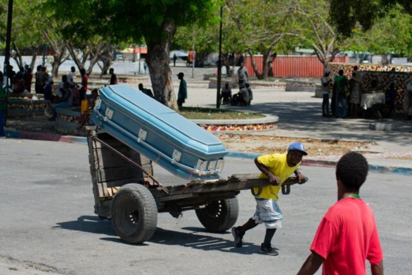 A man transports a coffin through the streets of the Haitian capital Port-au-Prince on Mar