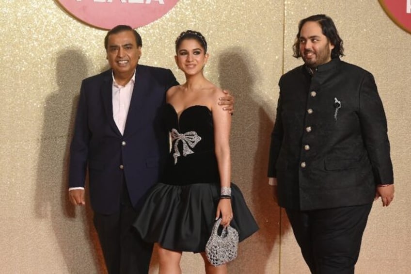 Reliance Industries chief Mukesh Ambani (L) poses with Radhika Merchant (C) and his son An