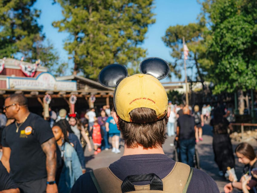 back view of visitor wearing mickey ears at Disneyland