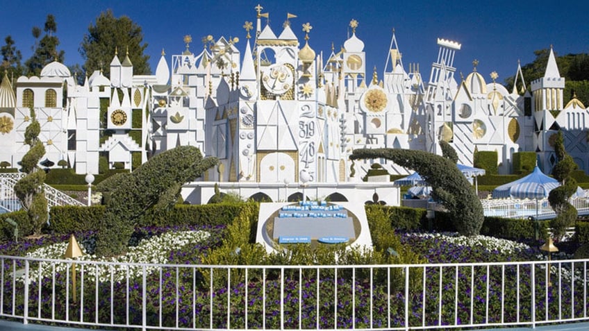 Disney Parks "It's a Small World" ride, featuring a castle and floral landscaping.