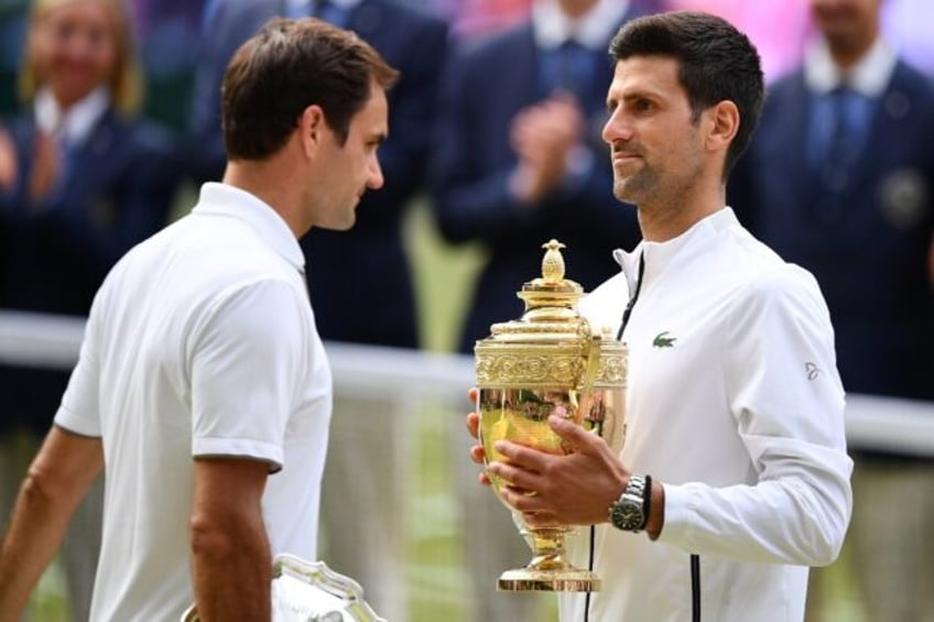 'Unbelievable': Novak Djokovic (right) holds the winner's trophy after defeating Roger Federer in the 2019 Wimbledon final