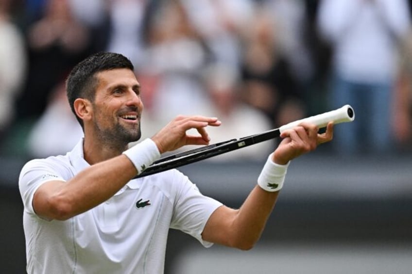 Celebration: Novak Djokovic imitates playing the violin as he celebrates winning against L