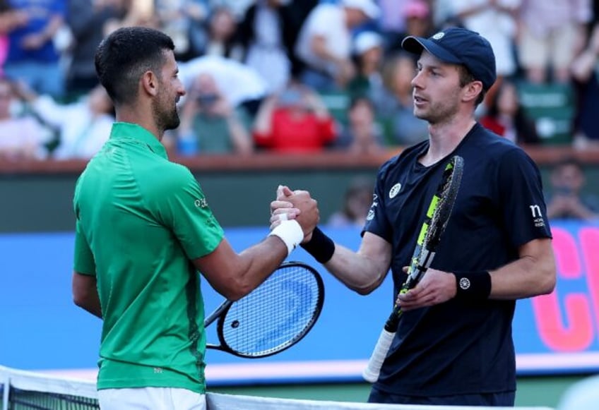 Five-time champion Novak Djokovic of Serbia shakes hands at the net after his three set de