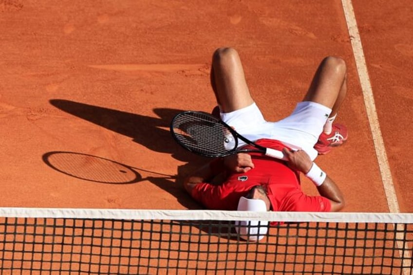 Down but not out: Novak Djokovic reacts after falling during a point against Australia's A