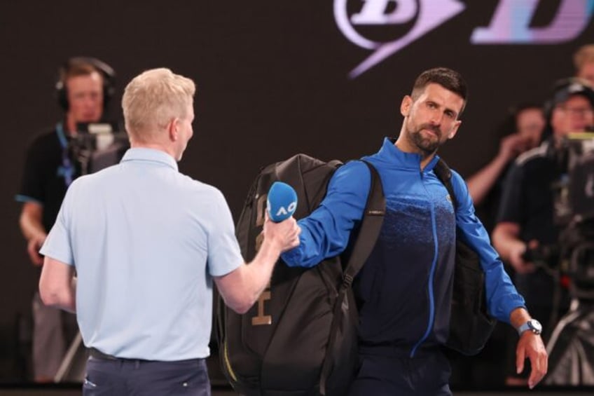 Serbia's Novak Djokovic gives back the microphone after speaking briefly on court