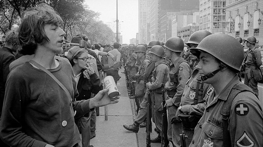 A demonstrator stands in front of a row of National Guard soldiers