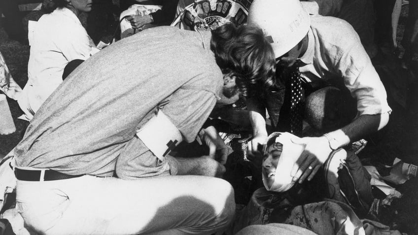 A medic assists an injured woman following protest against Vietnam War during the Democratic National Convention