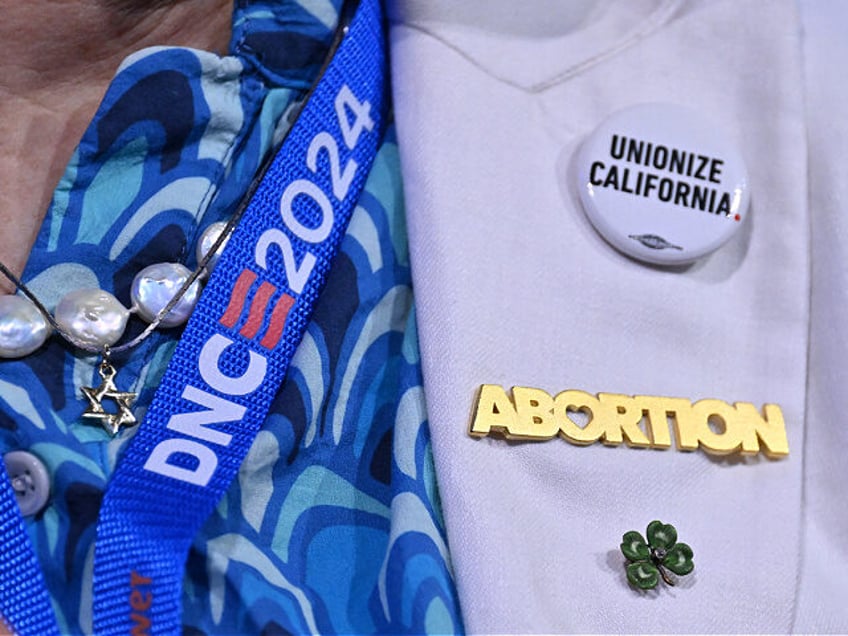 A an attendee wears a "Abortion" pin on the first day of the Democratic National Conventio