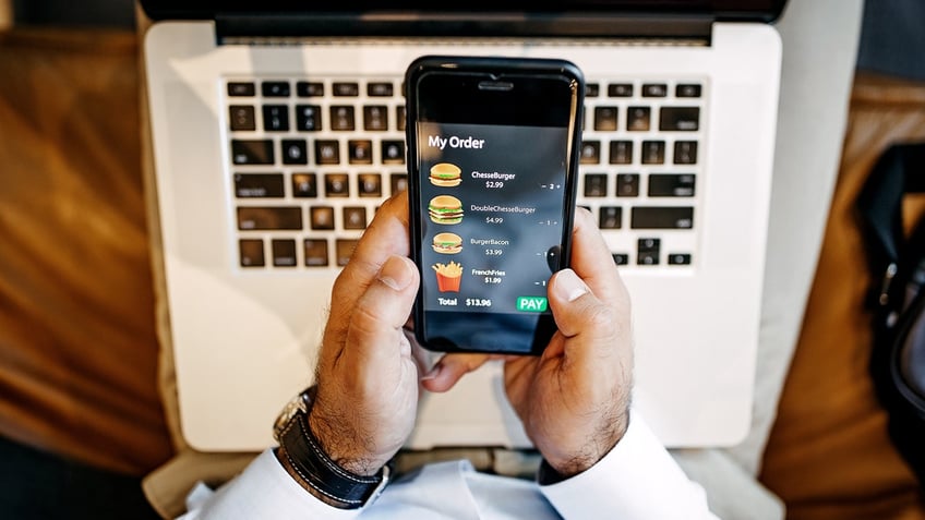 Food prices are seen on a man's phone app.