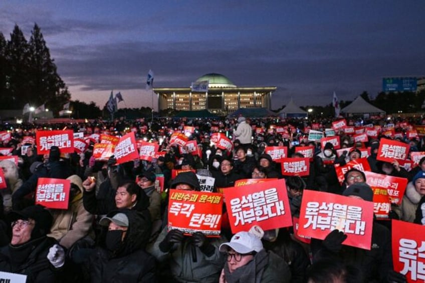 Protesters poured into the area around South Korea's National Assembly as lawmakers voted