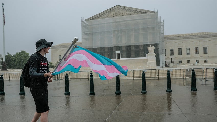 A protester waves a transgender pride flag outside the U.S. Supreme Court Building on June 18, 2025, in Washington, D.C. 