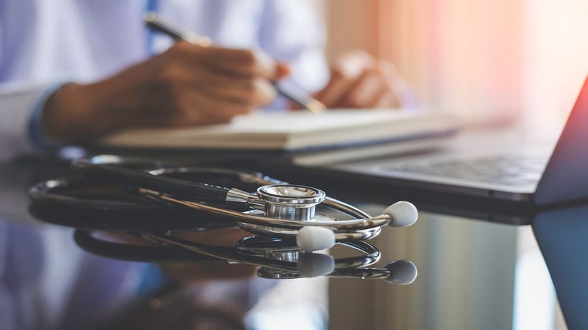 stock image, stethoscope, doctor writing