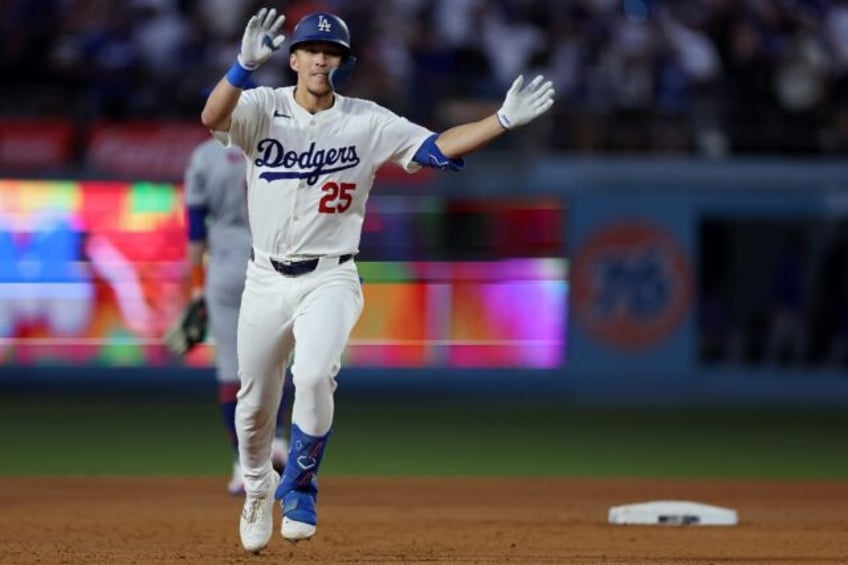 Tommy Edman of the Los Angeles Dodgers celebrates a two-run homer as he rounds the bases i