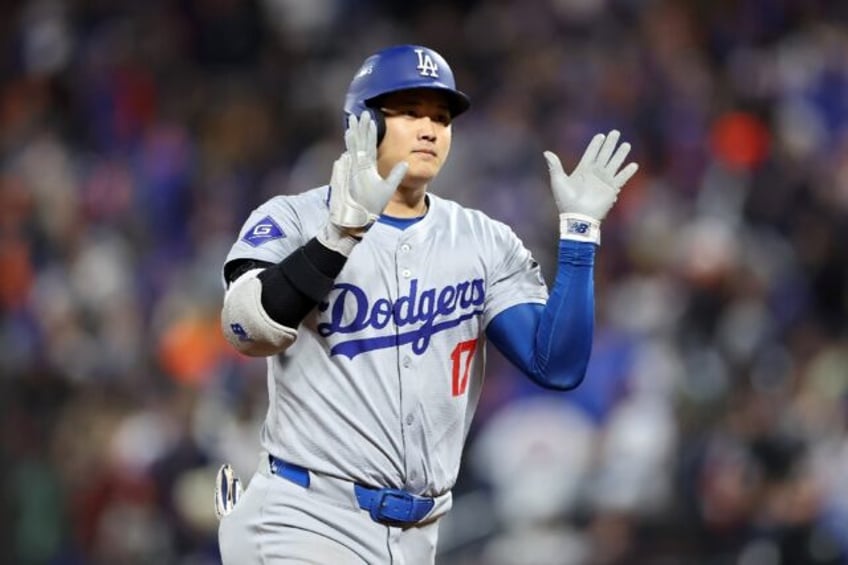 Shohei Ohtani of the Los Angeles Dodgers celebrates hitting a three-run homer in a Major L