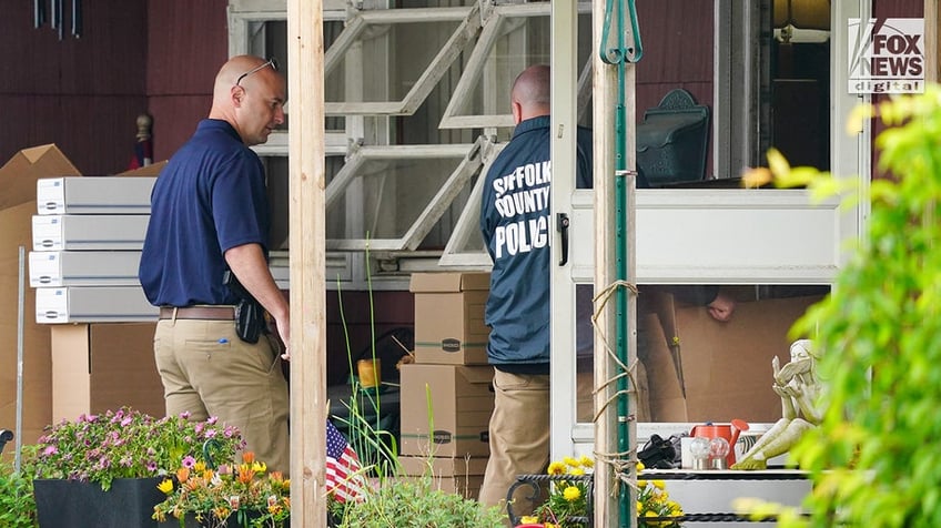 New York State and Suffolk County investigators remove bags of items marked with evidence tape from Rex Heuermann’s home in Massapequa Park