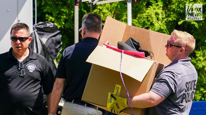 New York State and Suffolk County investigators remove bags of items marked with evidence tape from Rex Heuermann’s home in Massapequa Park