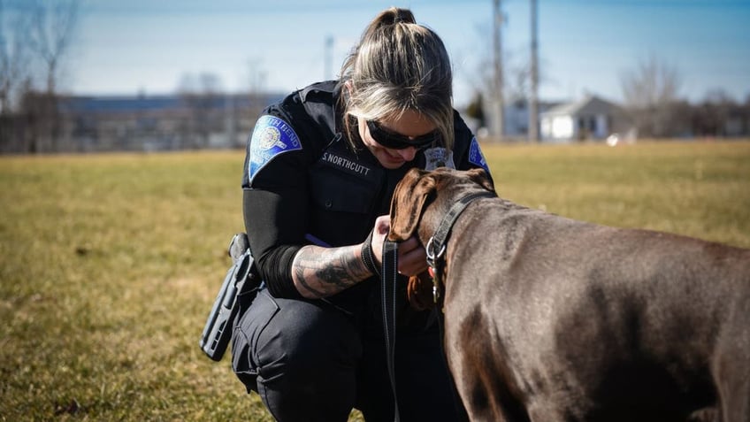 Officer Northcutt rubbing Zeus' face