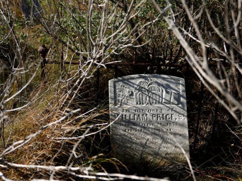 A gravestone dating to the late 1800s slowly sinks into the boggy ground in a small cemete