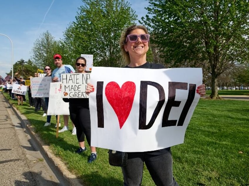 Woman holds sign supporting DEI