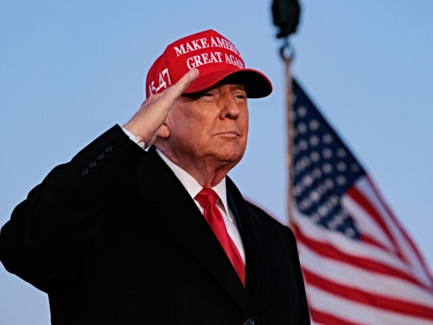 Former US President Donald Trump salutes during a campaign rally at the Schnecksville Fire