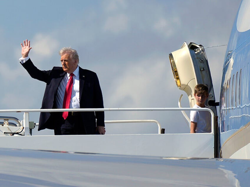 President Donald Trump, left, waves as he boards Air Force One with grandson Theodore, Iva