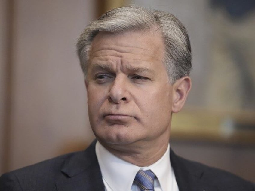 FBI Director Christopher Wray listens during a meeting of the Justice Department's El