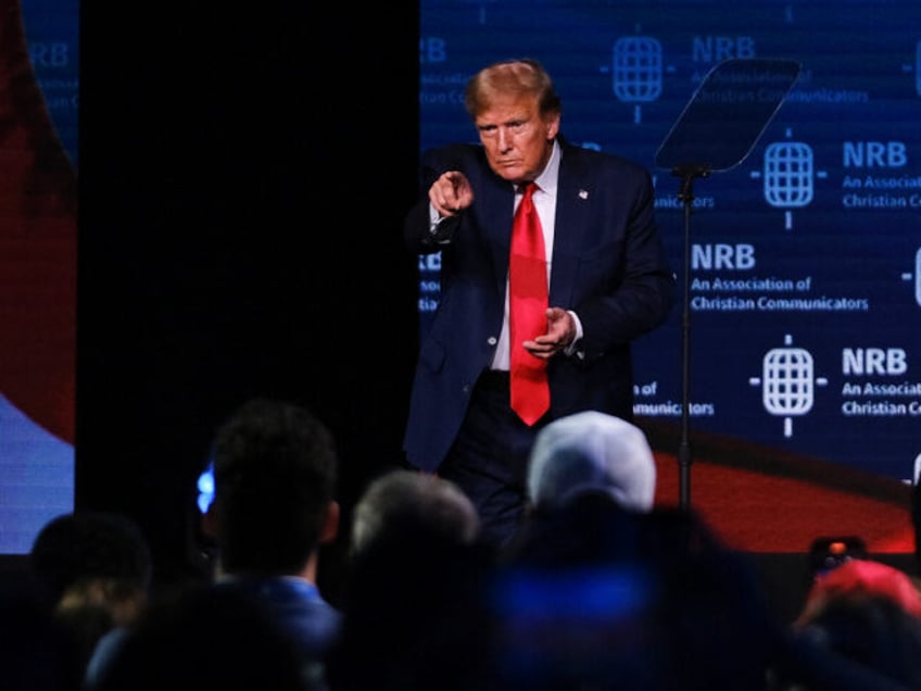 Former US President and 2024 presidential hopeful Donald Trump points as he walks onto sta