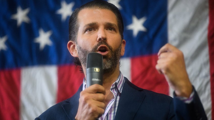 A photo of Donald Trump Jr in front of an American flag