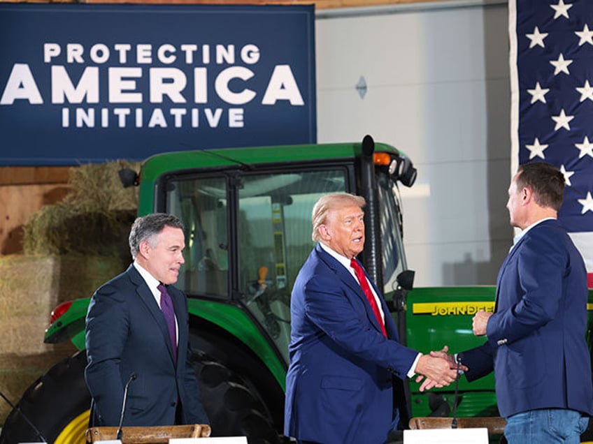 Republican presidential nominee, former U.S. President Donald Trump, (C) looks on during a