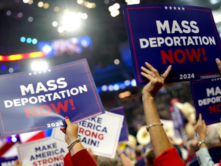 Delegates hold "Mass Deportations Now" campaign signs during the Republican Nati