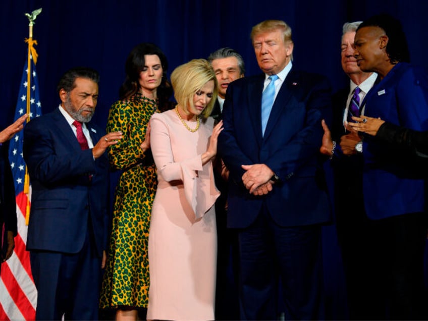 US President Donald Trump (C) stands in a prayer circle with faith leaders during a 'Evang