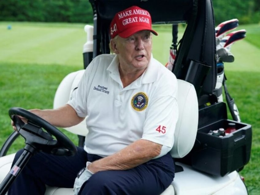 Former US President and 2024 Presidential hopeful Donald Trump drives a golf cart during t