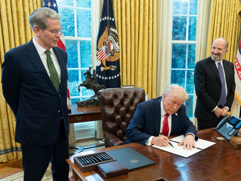 US President Donald Trump signs an executive order during a ceremony with Scott Bessent, U