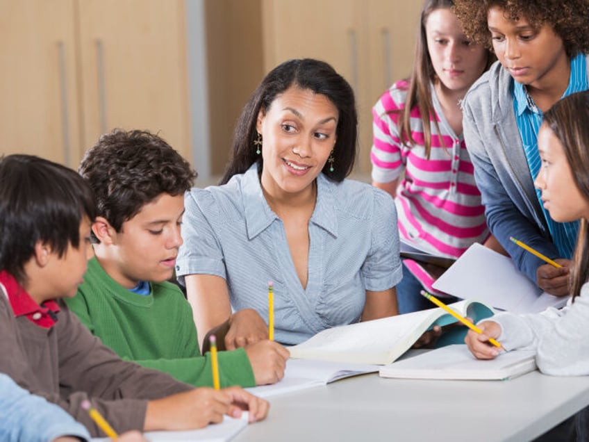 Multi-ethnic group of students with teacher in classroom.