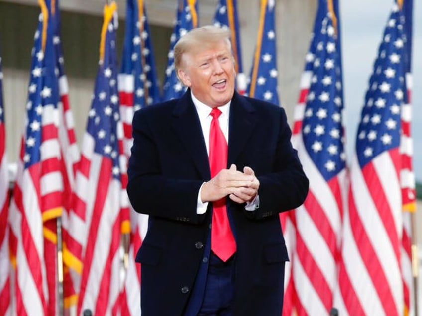 Former President Donald Trump applauds the crowd as he arrives to speak at a rally Saturda