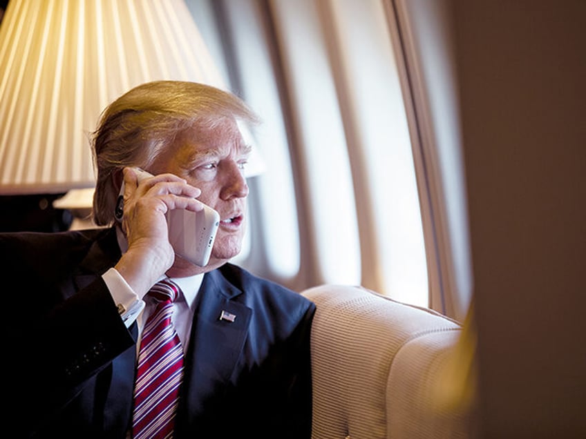 President Donald Trump talks on the phone aboard Air Force One during a flight to Philadel