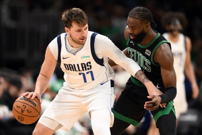 NBA scoring champion Luka Doncic, left, of the Dallas Mavericks goes against Boston's Jayl