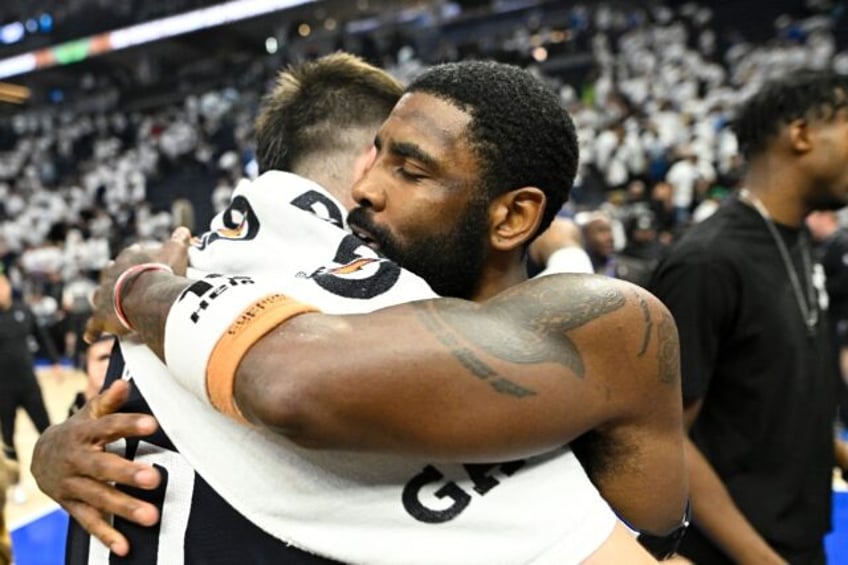 Dallas Mavericks' Kyrie Irving hugs teammate Luka Doncic after defeating the Minnesota Tim