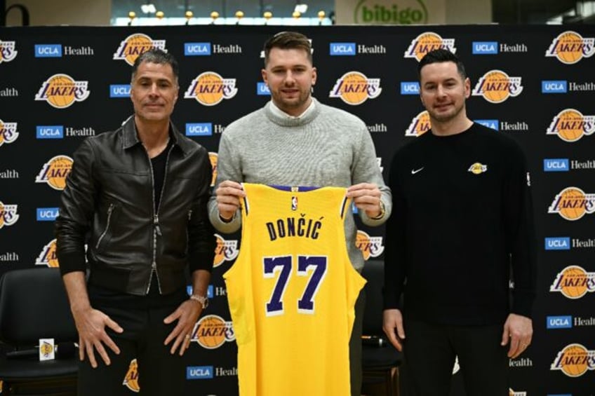 Luka Doncic (center) alongside Los Angeles Lakers general manager Rob Pelinka (left) and h