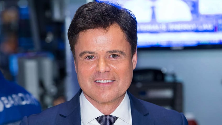 donny osmond smiling in front of screen